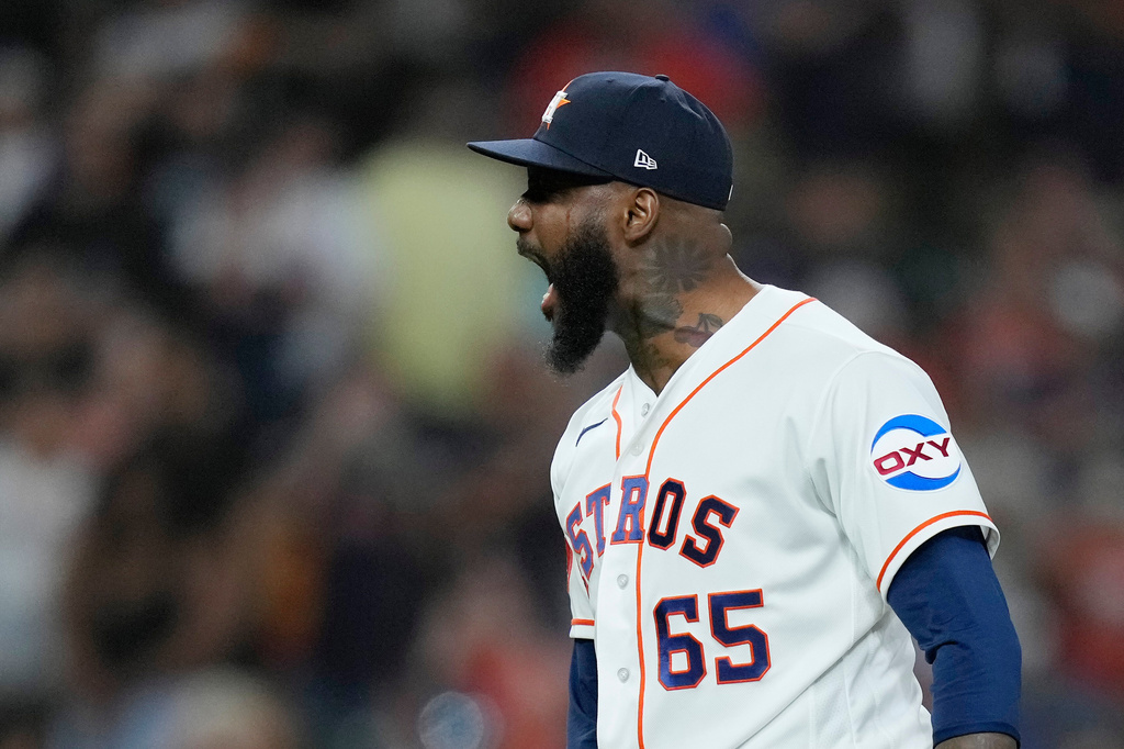 Houston Astros pitcher Enyel de Los Santos (65) yells after a strikeout to earn the save during the ninth inning of a baseball game against the Colorado Rockies, Tuesday, April 14, 2026, in Houston. (AP Photo/Kevin M. Cox)