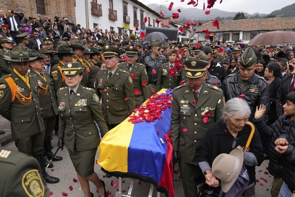 Police officers carry the coffin of Capt. Francisco Merchan, a police pilot killed when his helicopter was shot down by dissident a faction of the former FARC guerrilla group, after his funeral service in his hometown of Mongua, Colombia, Monday, Aug. 25, 2025. (AP Photo/Fernando Vergara)