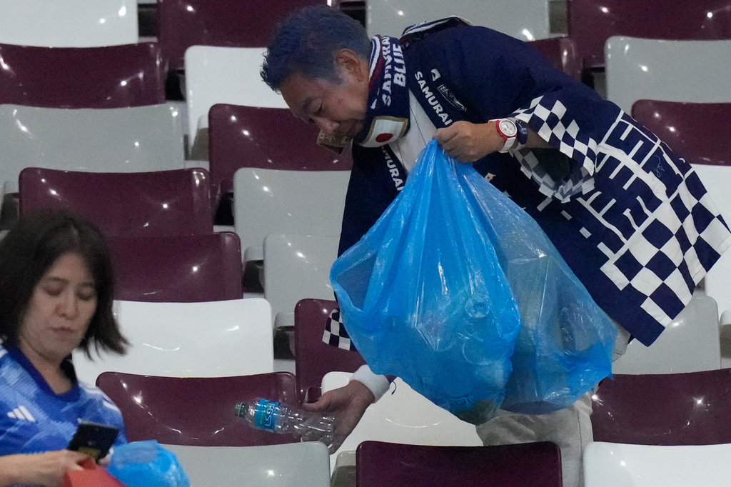 FILE - Japan supporters clean the stands at the end of the World Cup group E soccer match between Germany and Japan, at the Khalifa International Stadium in Doha, Qatar, on Nov. 23, 2022. (AP Photo/Eugene Hoshiko, File)