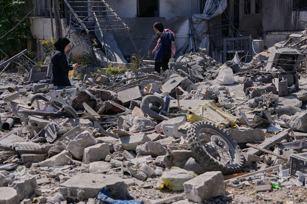 Sukaina al-Muhtadi, left, and her mother Aida who returned to their village following the announcement of an initial ceasefire agreement between the United States and Iran, search for their belongings between the rubble of their destroyed house in Nabatiyeh town, southern Lebanon, Tuesday, June 16, 2026. (AP Photo/Hussein Malla)