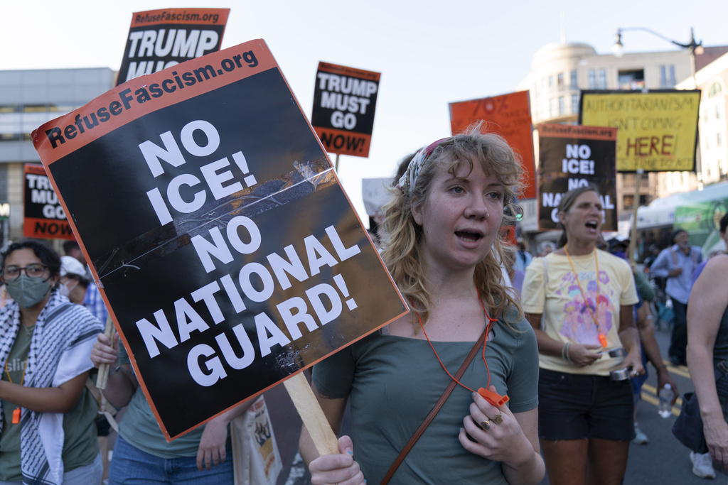 People protest against President Donald Trump's use of federal law enforcement and National Guard troops in the city during a march in downtown Columbia Heights neighborhood in Washington, Friday, Aug. 22, 2025. (AP Photo/Jose Luis Magana)