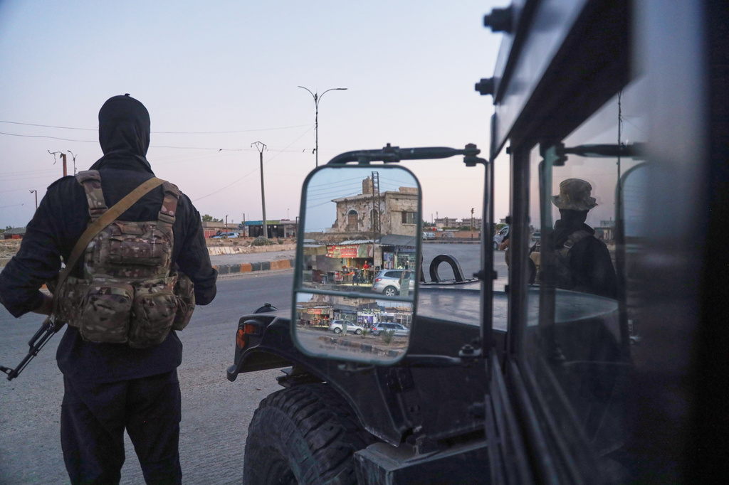 Soldiers formerly with the Kurdish-led Syrian Democratic Forces stand guard in Hasakah, northeastern Syria, Wednesday, Aug. 26, 2026. The force announced its dissolution Tuesday after completing its merger with the Syrian army. (AP Photo/Baderkhan Ahmad) ADDITION: Adds that the SDF announced its dissolution Tuesday after completing its merger with the Syrian army.