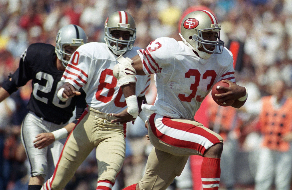 FILE - San Francisco 49ers Roger Craig (33) heads for the end zone for a first-quarter touchdown during an NFL football game against the Los Angeles Raiders at the Coliseum in Los Angeles, Sunday, Sept. 22, 1985. (AP Photo/Doug Pizac, File)