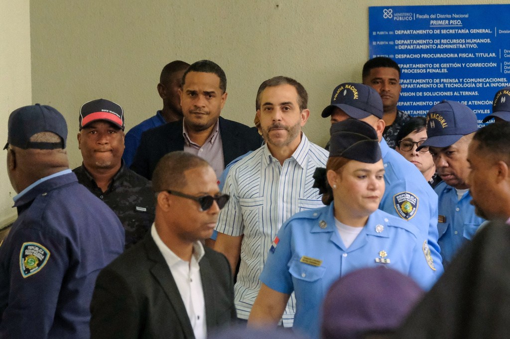 Antonio Espaillat, center, the owner of the Jet Set nightclub, whose roof collapse in 2025 resulted in fatalities, arrives at court for trial in Santo Domingo, Dominican Republic, Monday, April 27, 2026. (AP Photo/Ricardo Hernandez)