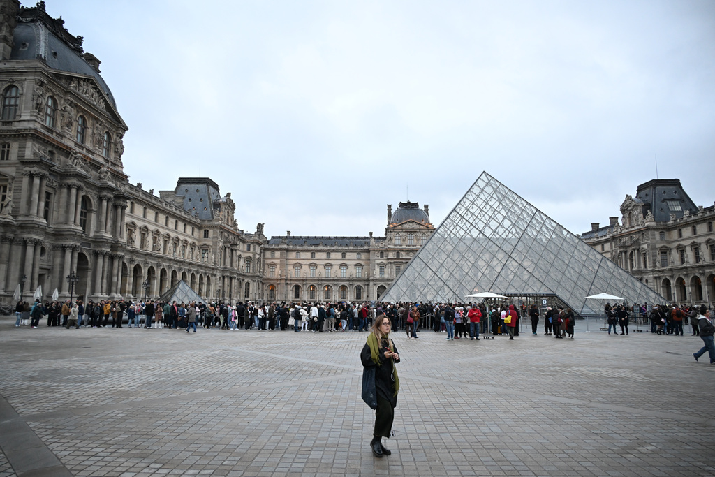 People queue to enter the Louvre museum that will remain closed for the day after Sunday's jewels robbery, Monday, Oct. 20, 2025 in Paris. (AP Photo/Emma Da Silva)