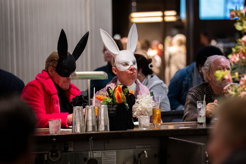 Two people wearing bunny masks drink at a bar during the Easter Bonnet Parade, Sunday, April 5, 2026 in New York. (AP Photo/Adam Gray)