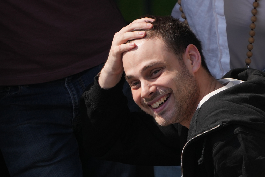 Freed Israeli hostage Alon Ohel gestures from a van as he arrives at Beilinson hospital in Petah Tikva, Israel, after he was released from Hamas captivity in the Gaza Stripl, Monday, Oct. 13, 2025. (AP Photo/Ariel Schalit)