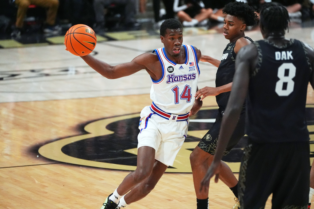 Kansas guard Melvin Council Jr., left, looks to pass the ball as Colorado guard Isaiah Johnson, back right, and forward Bangot Dak defend in the first half of an NCAA college basketball game Tuesday, Jan. 20, 2026, in Boulder, Colo. (AP Photo/David Zalubowski)