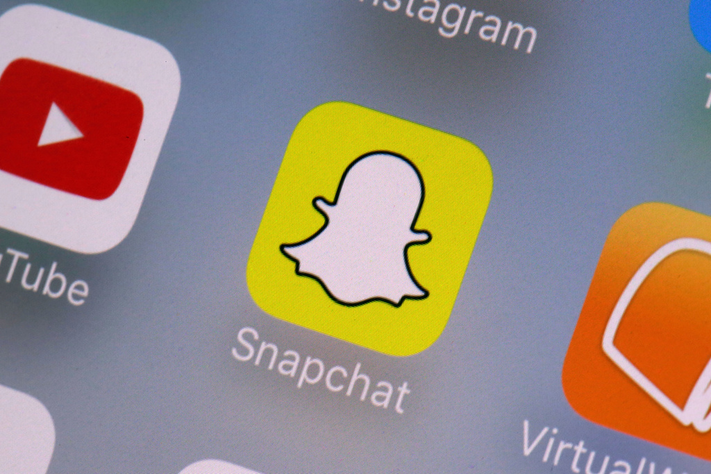 FILE - The Snapchat app on a mobile device is seen in New York. Snap Inc., Wednesday, Aug. 9, 2017. (AP Photo/Richard Drew, File)