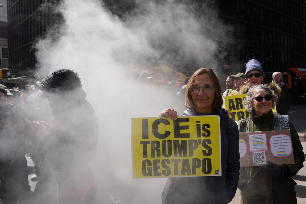 People hold up signs during a "No Kings" protest Saturday, March 28, 2026, in New York. (AP Photo/Adam Gray)