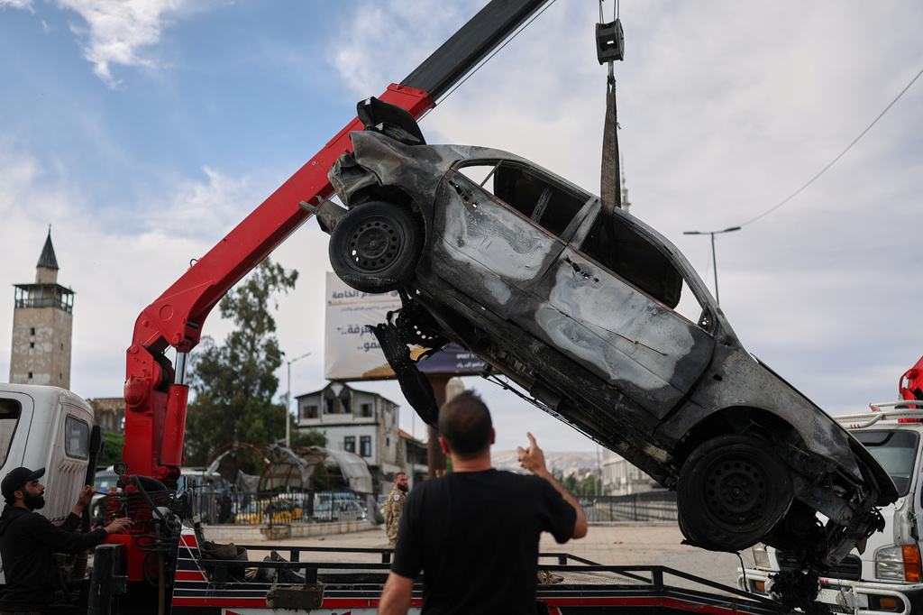 A damaged car is removed from the site of an explosion outside a Defense Ministry building in Damascus, Syria, Tuesday, May 19, 2026. (AP Photo/Ghaith Alsayed)