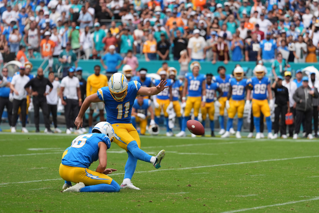 Los Angeles Chargers place kicker Cameron Dicker (11) kicks a game-winning field goal as JK Scott holds during the second half of an NFL football game against the Miami Dolphins Sunday, Oct. 12, 2025, in Miami Gardens, Fla. The Chargers won, 29-27. (AP Photo/Rebecca Blackwell)