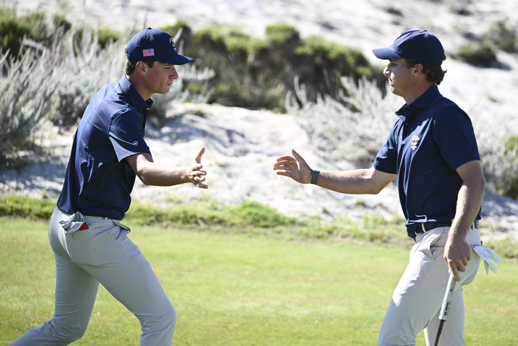 The USA team's Mason Howell, left, shakes hands with Jacob Modleski during Walker Cup golf matches against the Great Britain and Ireland team at Cypress Point Club on Sunday, Sept. 7, 2025, in Pebble Beach, Calif. (AP Photo/Thien-An Truong )