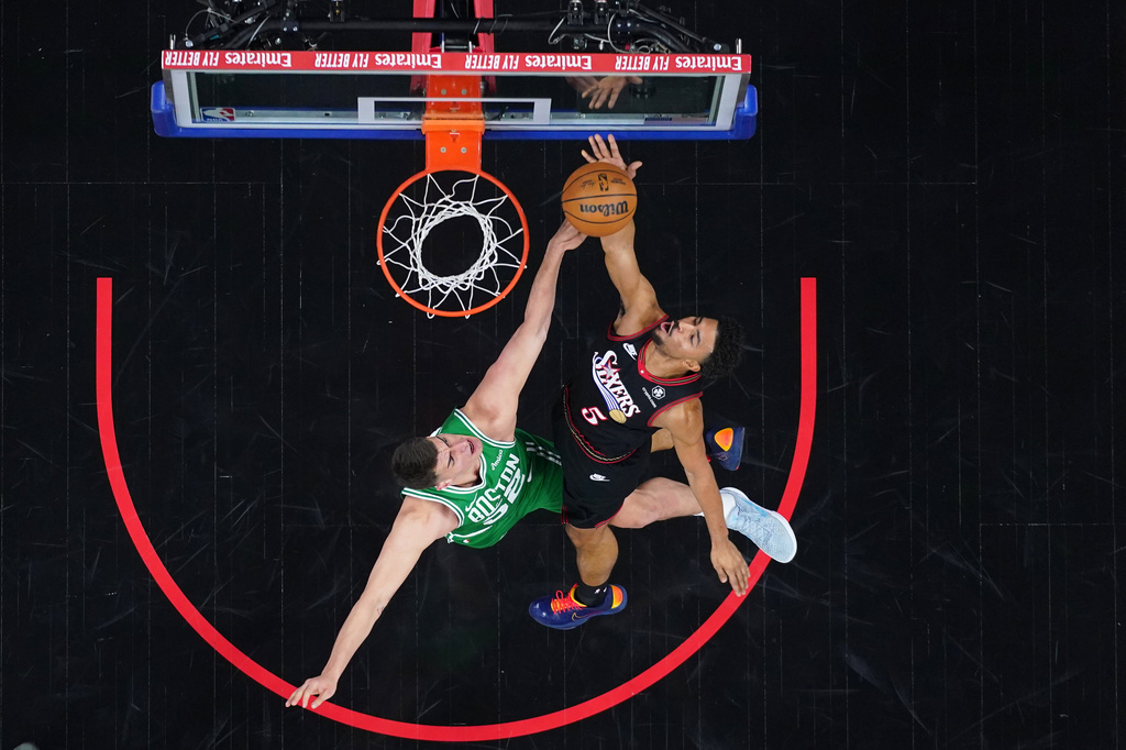 Philadelphia 76ers' Quentin Grimes, right, goes up for a shot against Boston Celtics' Luka Garza during the first half of Game 3 in a first-round NBA playoffs basketball series Friday, April 24, 2026, in Philadelphia. (AP Photo/Matt Slocum)