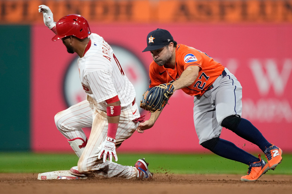 Philadelphia Phillies' Luis Arraez, left, slides into second for a double past Houston Astros second baseman Jose Altuve during the sixth inning of a baseball game Wednesday, Sept. 9, 2026, in Philadelphia. (AP Photo/Matt Slocum)