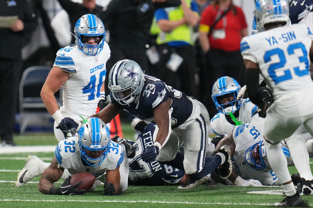 Detroit Lions safety Brian Branch recovers a fumble by Dallas Cowboys tight end Jake Ferguson (87) during the first half of an NFL football game Thursday, Dec. 4, 2025, in Detroit. (AP Photo/Paul Sancya)