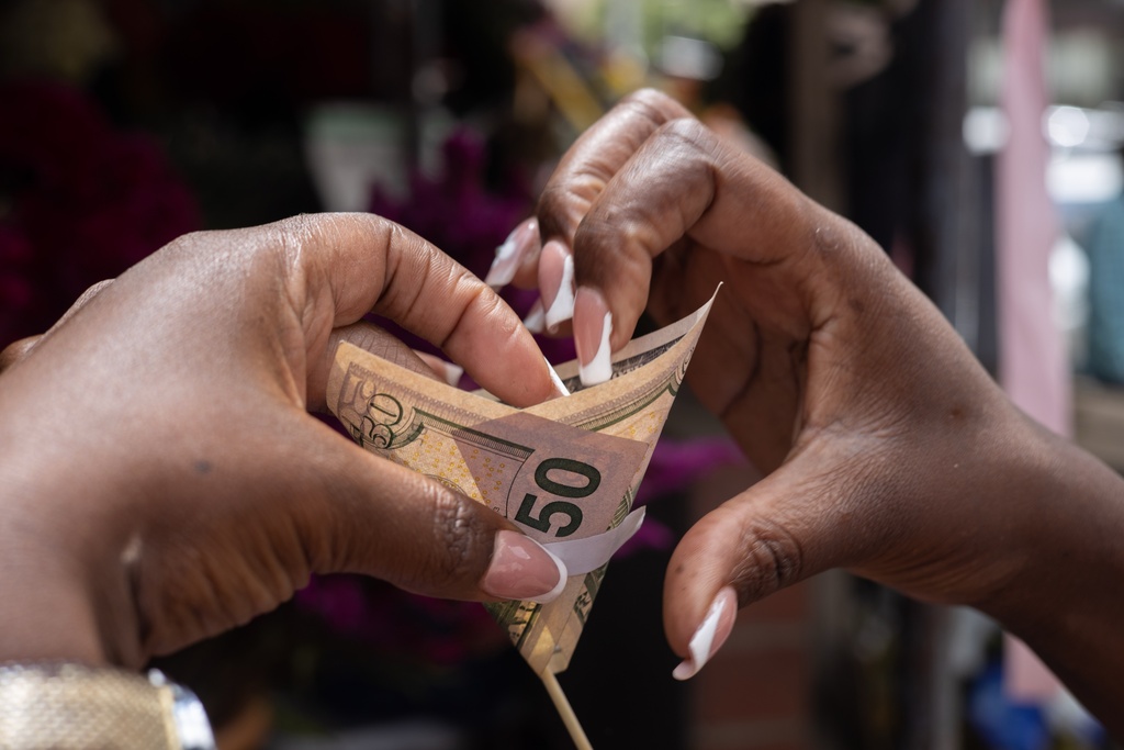 A florist makes a money bouquet designed for Valentine's Day at his stall in Harare, Zimbabwe, Tuesday, Feb. 10, 2026. (AP Photo/Aaron Ufumeli)