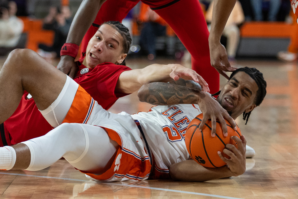 Clemson guard Dillon Hunter (2) gets fights for a loose ball against North Carolina guard Matt Able (3) during the first half of an NCAA college basketball game Tuesday, Jan. 20, 2026, in Clemson, S.C. (AP Photo/Scott Kinser)