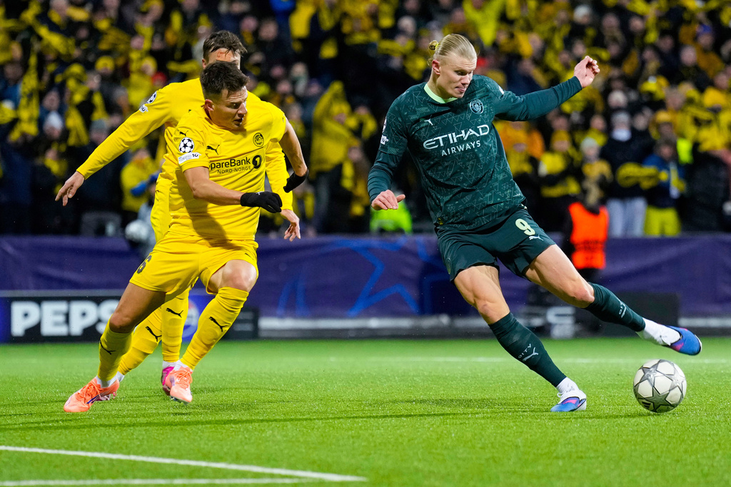 Manchester City's Erling Haaland, right, and Glimt's Jostein Gundersen battle for the ball during the Champions League soccer match between Bodo/Glimt and Manchester City in Bodo, Norway, Tuesday, Jan. 20, 2026. (Fredrik Varfjell/NTB via AP)