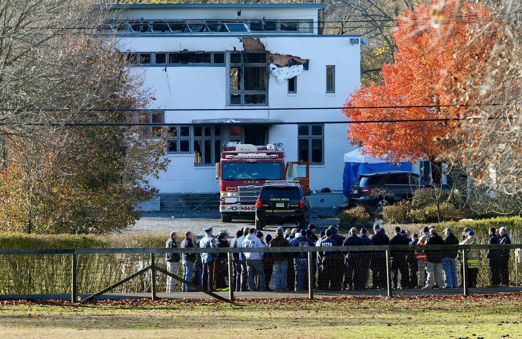 FILE - In this Nov. 21, 2018 file photo, authorities gather in Colts Neck, N.J., to investigate the aftermath of fatal fire. (AP Photo/Noah K. Murray, File)