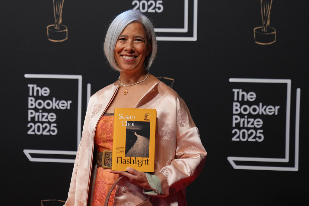 FILE - Author Susan Choi poses with her book 'Flashlight' as she arrives for the Booker Prize 2025 ceremony at Old Billingsgate in London, Monday, Nov. 10, 2025. (AP Photo/Kirsty Wigglesworth, File)
