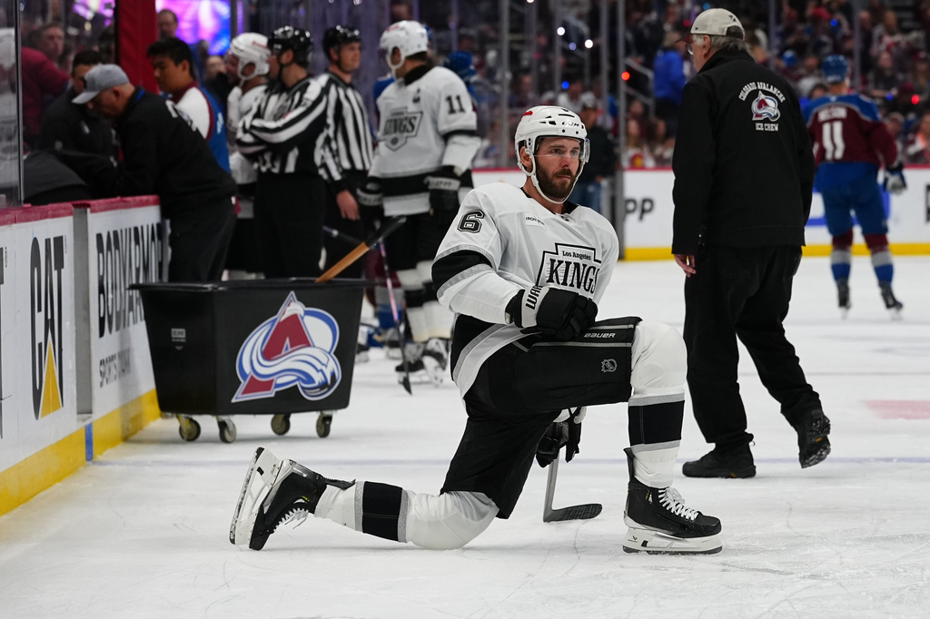 Los Angeles Kings defenseman Joel Edmundson stretches while waiting for a broken piece of glass to be replaced on the team's bench during the second period of Game 2 in the first round of the NHL hockey Stanley Cup playoffs against the Colorado Avalanche, Tuesday, April 21, 2026, in Denver. (AP Photo/Jack Dempsey)