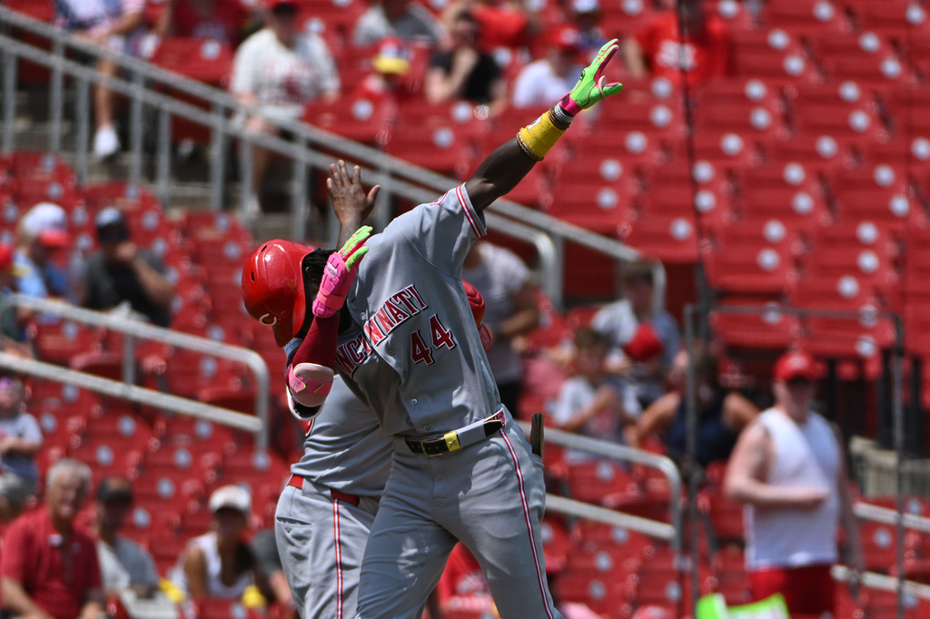 Cincinnati Reds' Elly de la Cruz (44) reacts with third base coach Willie Harris, back, after hitting a home run against the St. Louis Cardinals during the third inning of a baseball game, Sunday, July 26, 2026, in St. Louis. (AP Photo/Jeff Le)