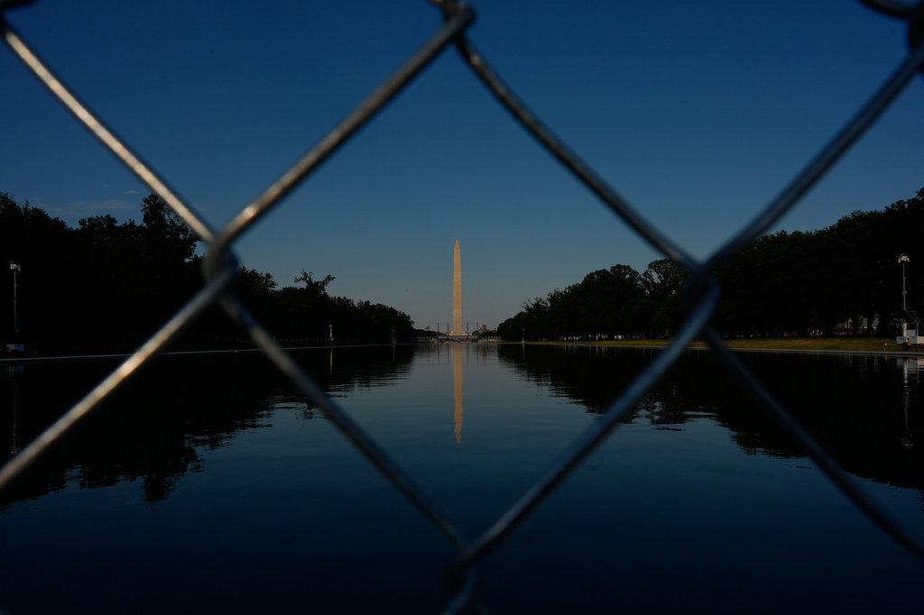 The Washington Monument, reflected in the Lincoln Memorial Reflecting Pool, is seen behind a chain link fence Thursday, June 25, 2026, in Washington. (AP Photo/Carolyn Kaster)