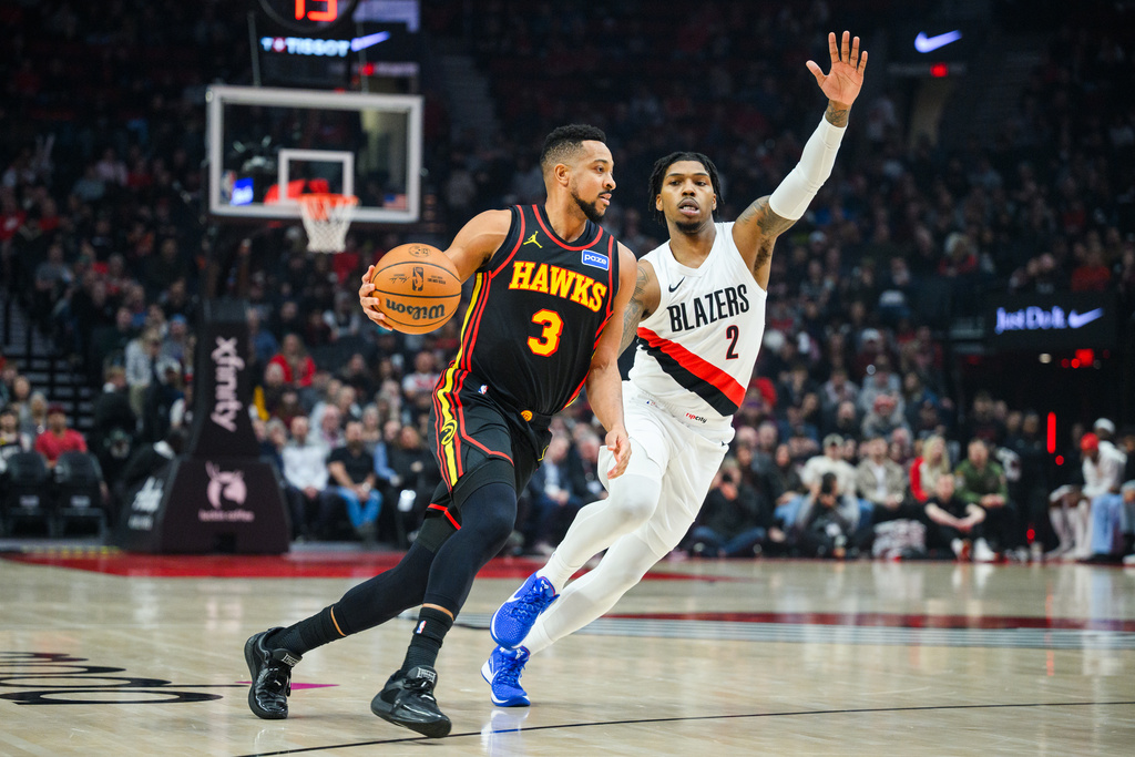 Atlanta Hawks guard CJ McCollum (3) dribbles past Portland Trail Blazers guard Caleb Love (2) during the first half of an NBA basketball game on Thursday, Jan. 15, 2026, in Portland, Ore. (AP Photo/Molly J. Smith)
