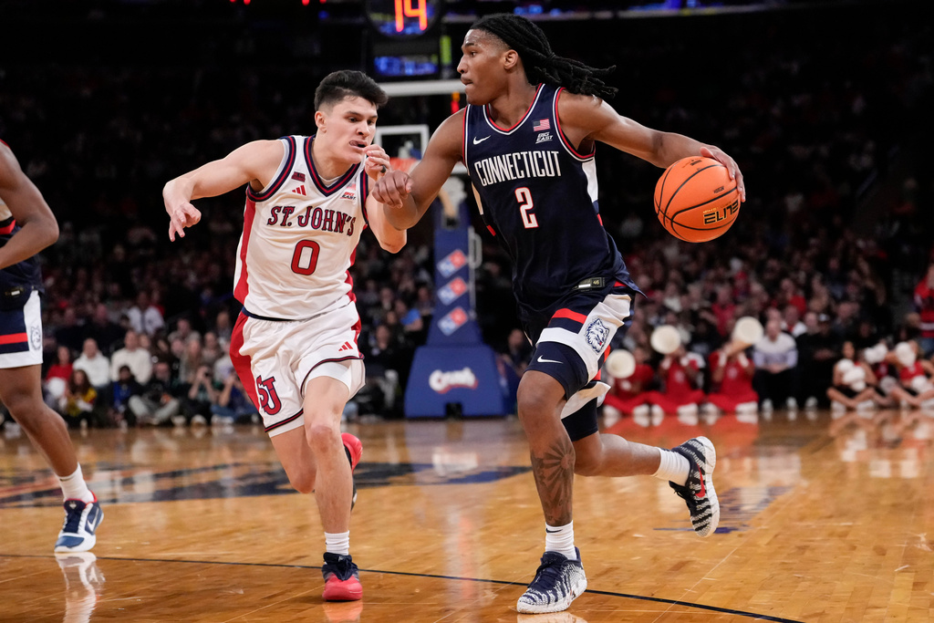 UConn guard Silas Demary Jr. (2) drives past St. John's guard Dylan Darling (0) during the half of an NCAA college basketball game in the championship of the Big East tournament, Saturday, March 14, 2026, in New York. (AP Photo/Yuki Iwamura)