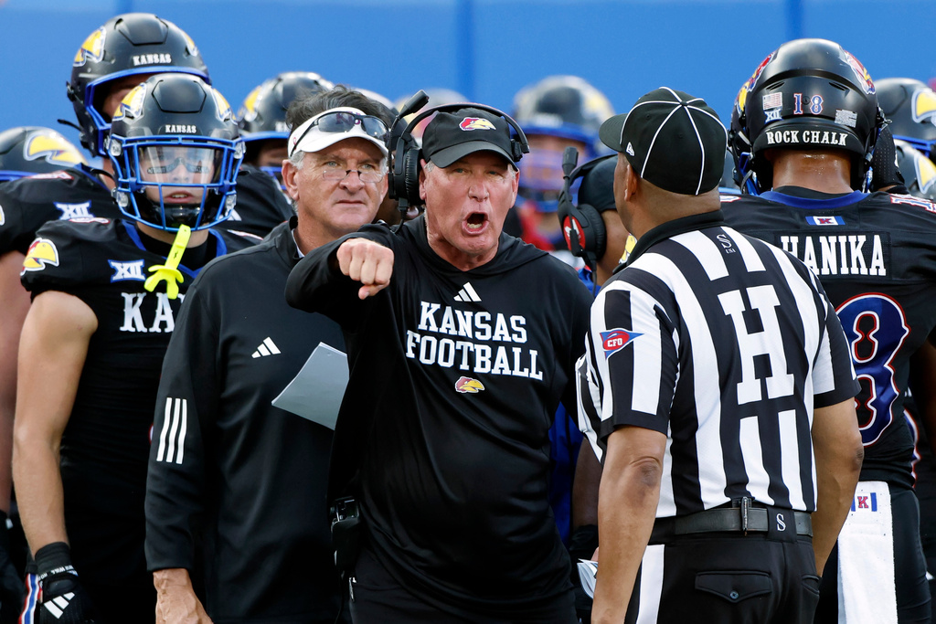 FILE - Kansas head coach Lance Leipold, center, disputes a call by an official during the first half of an NCAA collage football game against West Virginia Sept. 20, 2025, in Lawrence, Kan. (AP Photo/Colin E. Braley, File)