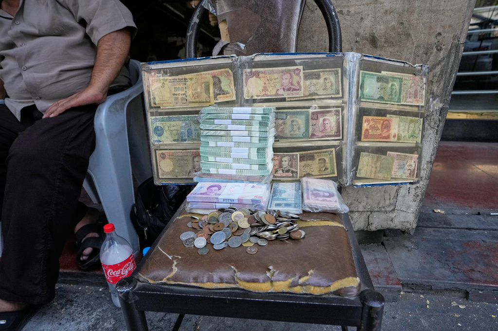 Current and pre-revolution Iranian banknotes are displayed by a street money exchanger at Ferdowsi square, a hub for foreign currency trading in downtown Tehran, Iran, Monday, Aug. 24, 2026. (AP Photo/Vahid Salemi)
