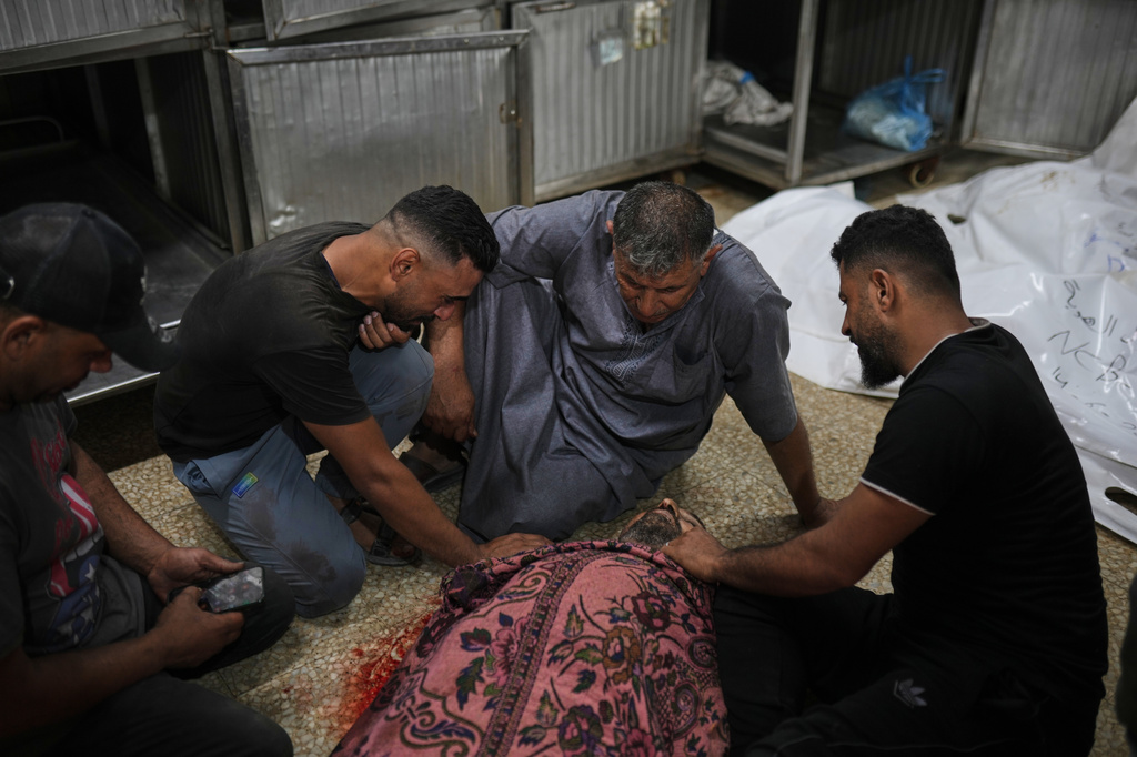 Relatives of Hani Abu Sweilem mourn beside his body at Al-Shifa Hospital in Gaza City after he was killed in an Israeli airstrike, Sunday, June 14, 2026. (AP Photo/Jehad Alshrafi)