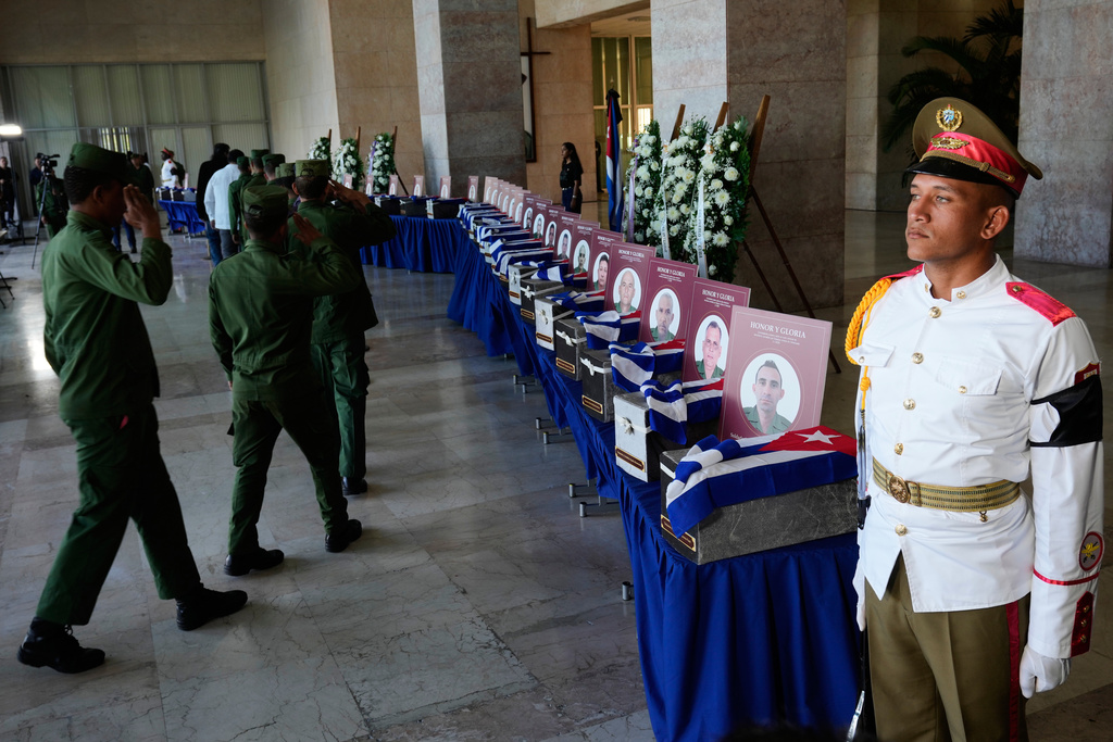 Military members pay their last respects to Cuban officers who were killed during the U.S. operation in Venezuela that captured Venezuelan President Nicolas Maduro, at the Ministry of the Revolutionary Armed Forces where the urns containing the remains are displayed during a ceremony in Havana, Cuba, Thursday, Jan. 15, 2026. (AP Photo/Ramon Espinosa)