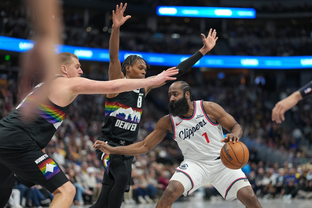 Los Angeles Clippers guard James Harden, right, looks to pass the ball under defensive pressure from Denver Nuggets center Nikola Jokić, left, and guard Peyton Watson in the second half of an NBA basketball game Friday, Jan. 30, 2026, in Denver. (AP Photo/David Zalubowski)