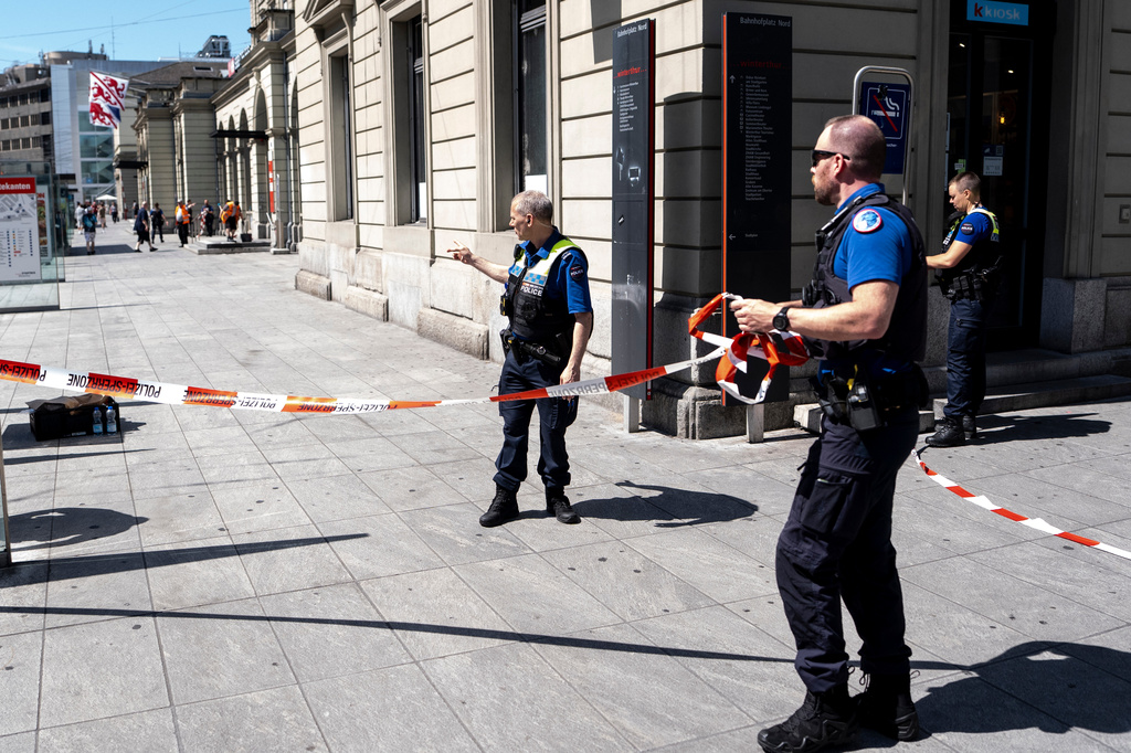 Police officers remove tape following a stabbing attack at the train station in Winterthur, Switzerland, Thursday, May 28, 2026. (Claudio Thoma/Keystone via AP)