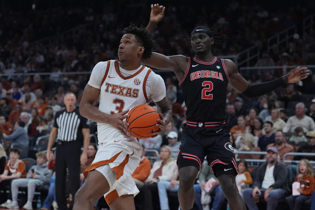 Texas guard Dailyn Swain (3) drives past Georgia center Somtochukwu Cyril (2) during the second half of an NCAA college basketball game in Austin, Texas, Saturday, Jan. 24, 2026. (AP Photo/Eric Gay)