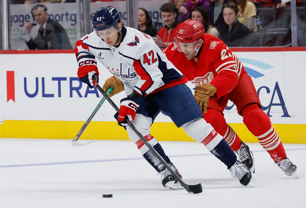 Washington Capitals defenseman Martin Fehervary (42) is pursued by Detroit Red Wings left wing James van Riemsdyk (21) during the first period of an NHL hockey game Sunday, Dec. 21, 2025, in Detroit. (AP Photo/Duane Burleson)