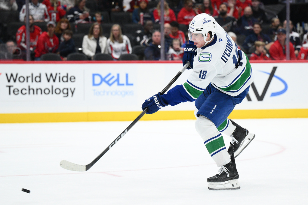 Vancouver Canucks left wing Drew O'Connor shoots the puck during the second period of an NHL hockey game against the Washington Capitals, Sunday, Oct. 19, 2025, in Washington. (AP Photo/Nick Wass)