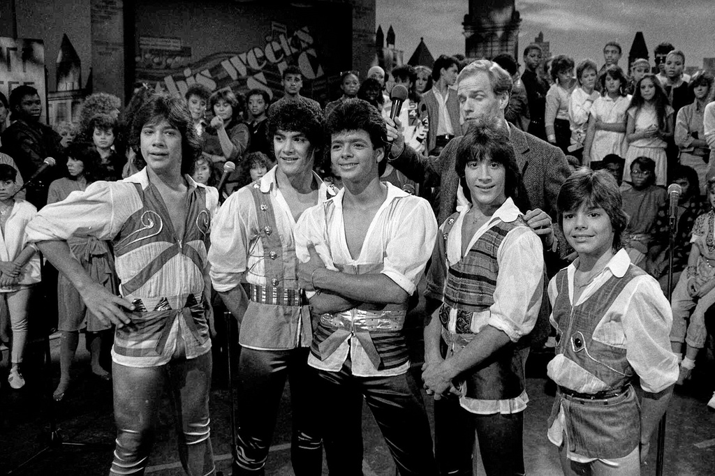 FILE - Music group Menudo, from left, Ray Reyes, Charlie Massó, Robby Rosa (Draco Rosa), Roy Roselló and Ricky Martin appear on the set of "This Week's Music" in New York on Oct. 7, 1984. (AP Photo/Mario Suriani, File)