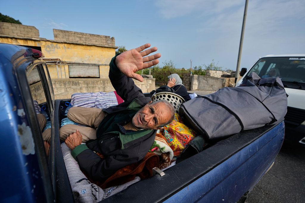 A displaced man gestures lying over belongings on a mini pickup, in Qasmiyeh near Tyre city, south Lebanon, as he returns with his family to their village following a ceasefire between Hezbollah and Israel, Friday, April 17, 2026. (AP Photo/Mohammed Zaatari)