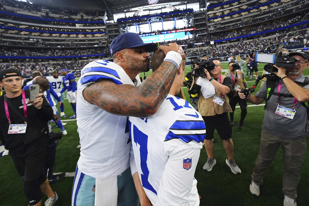 Dallas Cowboys quarterback Dak Prescott (4) gives place kicker Brandon Aubrey, right, a kiss on the head after the team's overtime win in an NFL football game against the New York Giants Sunday, Sept. 14, 2025, in Arlington, Texas. (AP Photo/Julio Cortez)
