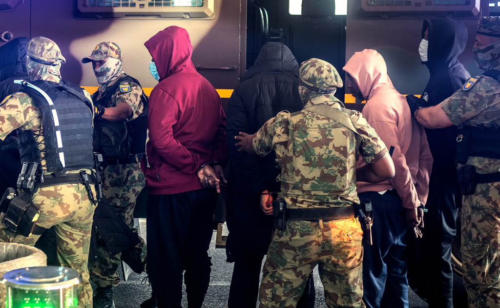 Members of the elite tactical police unit escort six Nigerians nationals being extradited to US for participating in romance scams, in Cape Town, South Africa, Friday, Sept. 11, 2026. (AP Photo)