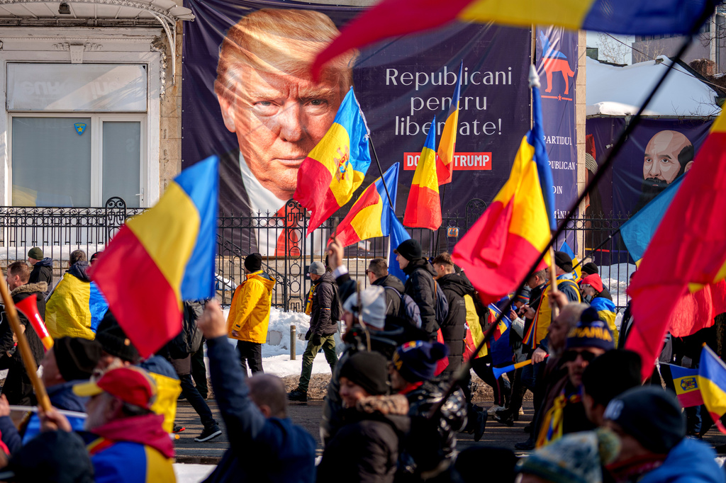 FILE - A banner of President Donald Trump reads "Republicans for Freedom" as supporters of Calin Georgescu, winner of the first round of presidential election, which was annulled by the Constitutional Court, hold a protest march in Bucharest, Romania, Feb. 22, 2025, File. (AP Photo/Andreea Alexandru, File)