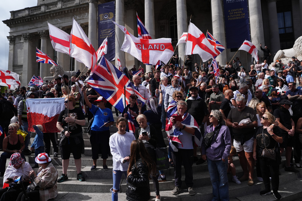 Police standby as people gather outside the Portsmouth Guildhall, Portsmouth, England, to take part in an anti-migrant South Coast Patriots march, Saturday Sept. 12, 2026. (Jonathan Brady/PA via AP)