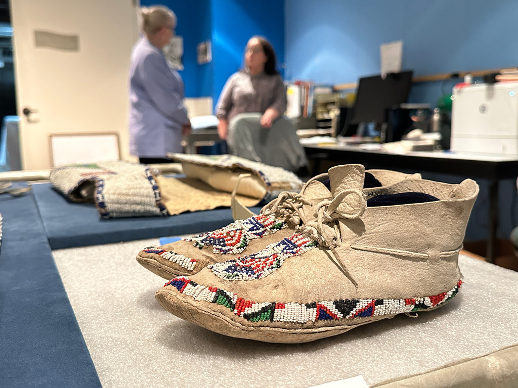 Decades-old moccasins from Taos Pueblo that feature red, white and blue beads are prepared for display as part of the "Stars, Stripes and First Americans" exhibition at the Museum of Indian Arts and Culture in Santa Fe, N.M., on Monday, May 11, 2026. (AP Photo/Susan Montoya Bryan)