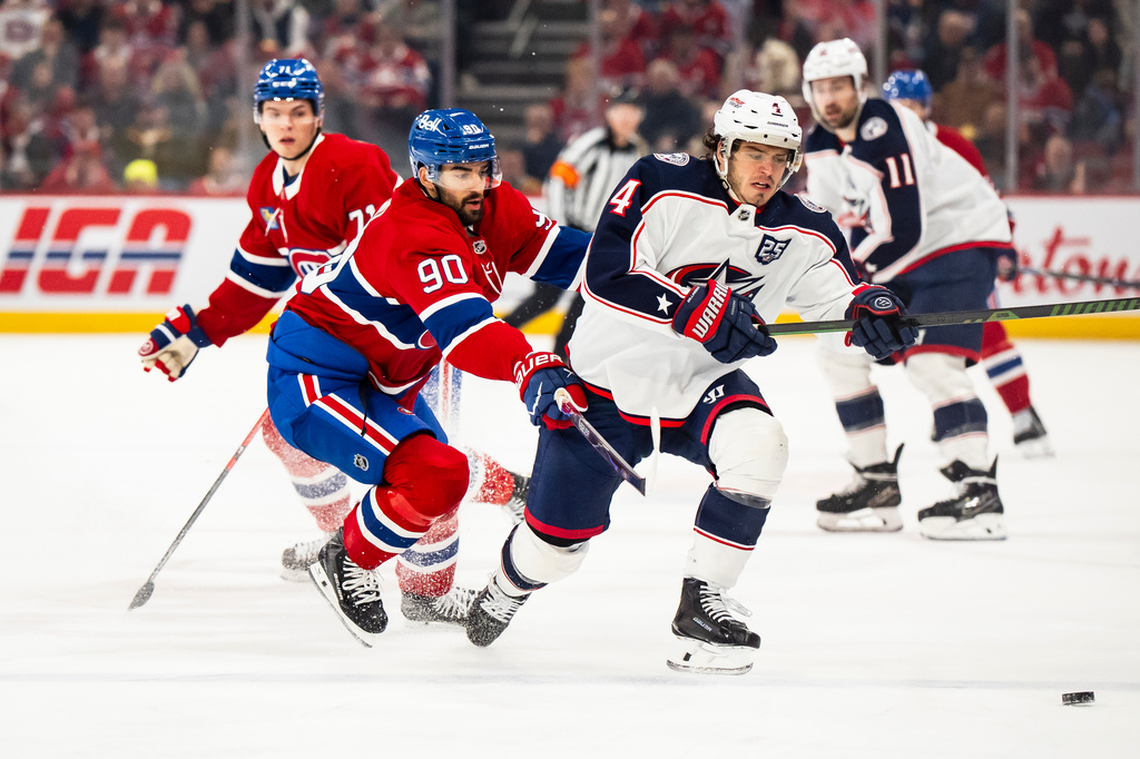 Columbus Blue Jackets' Cole Sillinger (4) and Montreal Canadiens' Joe Veleno (90) vie for the puck during first-period NHL hockey game action in Montreal, Saturday, April 11, 2026. (Christopher Katsarov/The Canadian Press via AP