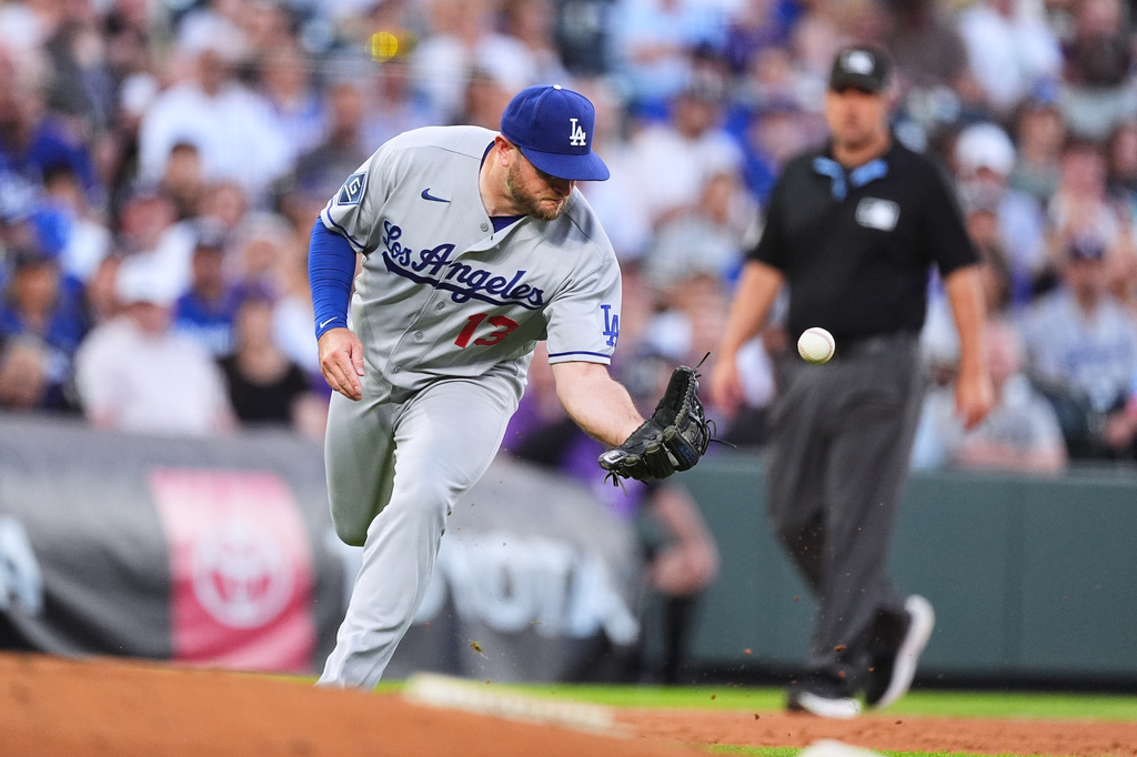 Los Angeles Dodgers third baseman Max Muncy tries to field a single off the bat of Colorado Rockies' Braxton Fulford in the second inning of a baseball game Tuesday, Aug. 18, 2026, in Denver. (AP Photo/David Zalubowski)
