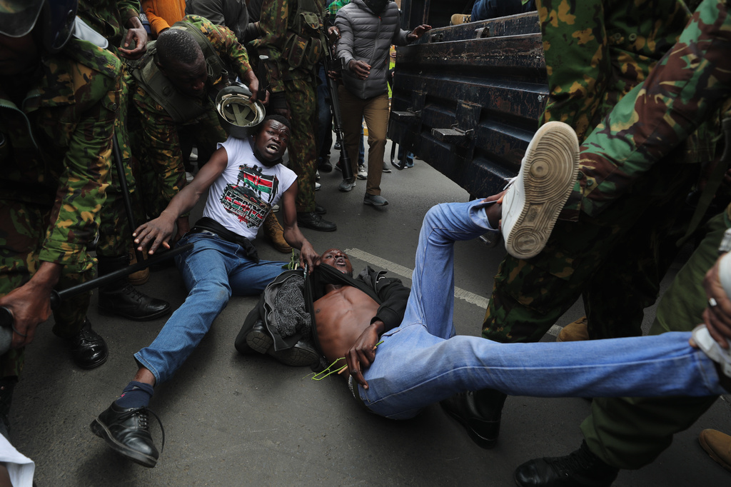 Kenyan police officers arrest protesters near parliament during a demonstration to mark two years since more than 60 people died in anti-government protest that resulted in the storming of the parliament, Nairobi, Kenya, Thursday, June 25, 2026. (AP Photo/Henry Naminde)