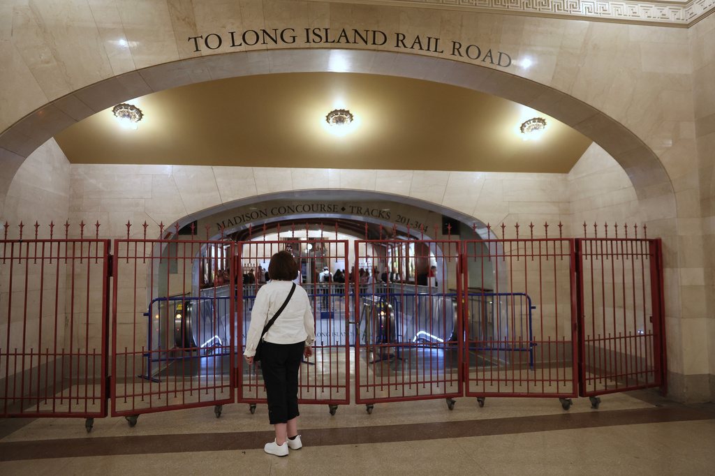 A passenger looks at a closed off entrance to the Long Island Rail Road at Grand Central station, Saturday, May 16, 2026, in New York, on the first day of a strike after five unions representing about half the LIRR's workforce walked off the job. (AP Photo/Heather Khalifa)